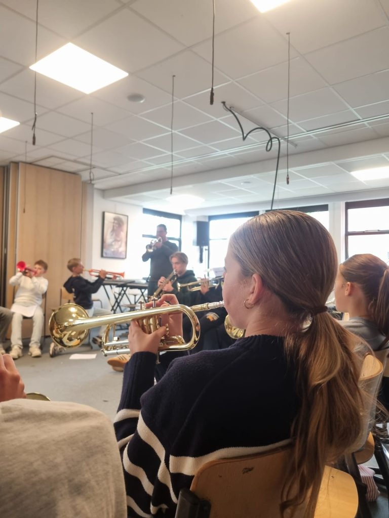 Trompet bespelen tijdens muziekproject.